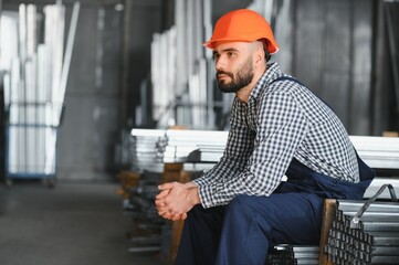 Factory worker measures the metal profile