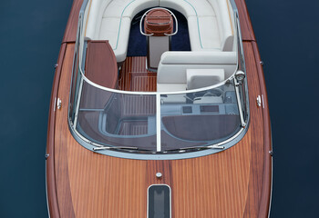 Front deck Luxurious lacquered wooden big boat on the water top view. Large expensive varnished wooden boat top view