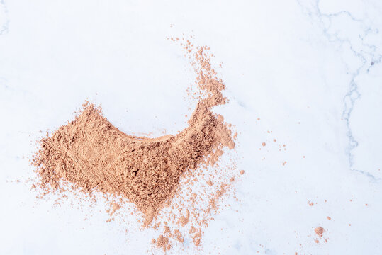 moroccan red clay, cosmetic clay powder on white marble background.