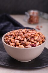 Bowl with dry kidney beans on table, closeup