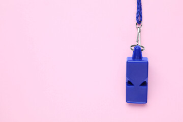 One blue whistle with cord on pink background, top view. Space for text
