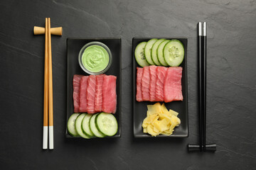 Tasty sashimi sets (pieces of fresh raw tuna), sliced cucumber, wasabi sauce and ginger slices on...