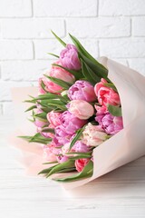 Bouquet of beautiful tulips on white wooden table, closeup