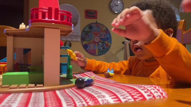 3-year-old sweet black child playing with daddy at home with his toy house