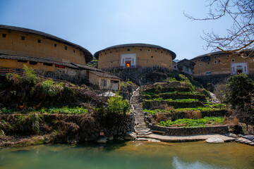 Fototapeta na wymiar Yongding, Longyan, Fujian province, China - Mar 1st, 2021: The small pond in front of Fujian earthern buildings (also known as Hakka tulou) in mountains. These buildings are in Chuxi village.