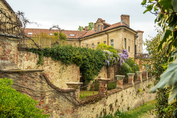 Fototapeta na wymiar Exterior of San Sebastiano da Po Castle, Torino, Piemonte region, Italy surrounded by nature with beautiful wisteria plants hanging from the balconies and windows