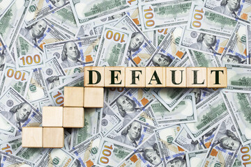 Background of US dollar bills with word default on a wooden ladder. crisis escalation