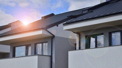 Terraced family homes in newly developed housing estate. The real estate market in the suburbs. New single family houses in a new development area. Residential homes with modern facade. 