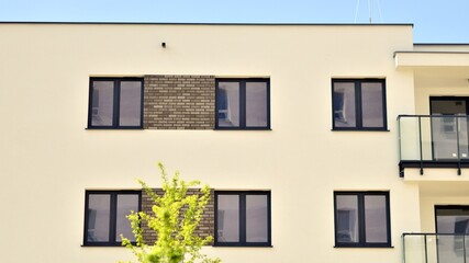 Fototapeta premium Modern apartment buildings on a sunny day with a blue sky. Facade of a modern apartment building. Contemporary residential building exterior in the daylight. 
