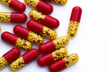 Transparent supplement pill with yellow and red granules, medicine in a see-through bottle.  Many...