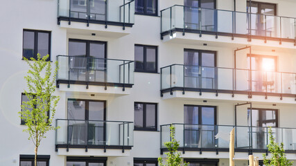 Fototapeta premium Modern apartment buildings on a sunny day with a blue sky. Facade of a modern apartment building. Contemporary residential building exterior in the daylight. 