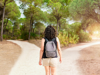 Woman choosing to take a light path or a dark path in a forest. Concept of decision making in life.
