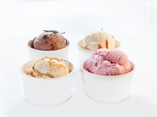 Vanilla caramel white chocolate gelato ice cream in an unbranded paper cup with plastic spoon.