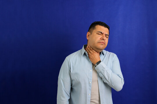 Dark-haired Latino adult man is sick, has a sore throat and suffers from strep cough and tonsil infections