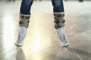 Ice skates, woman shoes and legs of skater training, recreation and skate on frozen floor, arena or stadium. Winter, entertainment and feet of female person balance, active or learning figure skating