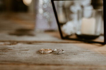 Gold & Silver Wedding rings with diamonds on rustic wood table