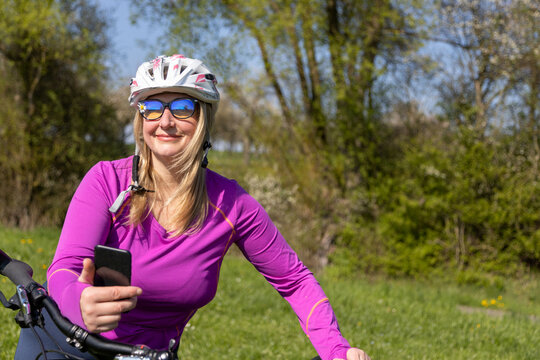 a woman of mature age with a bicycle in a pink sweater