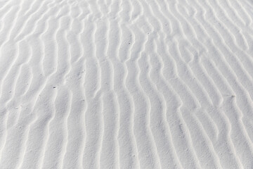 Fototapeta na wymiar Close up of patterns the wind has blown into white sand