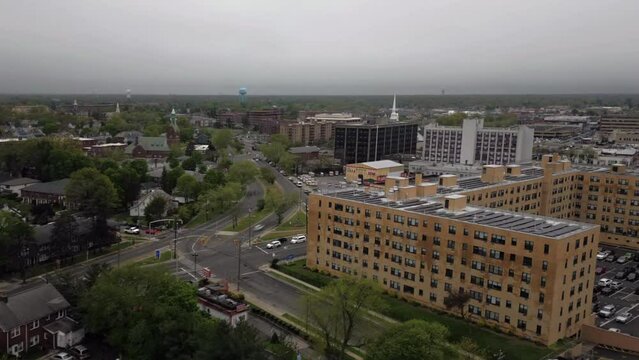 An aerial time lapse over Hempstead, New York during a cloudy day on the weekend. The drone camera truck left and pan right then dolly out from an apartment building with solar panels on the roof.