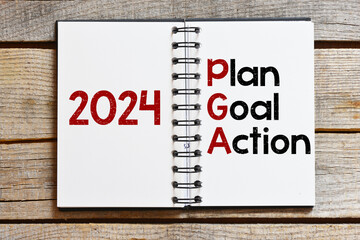 2024 plan, goal, action in an office notebook.