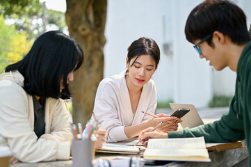 Pretty Asian female college student focuses on listening to her friend explain math