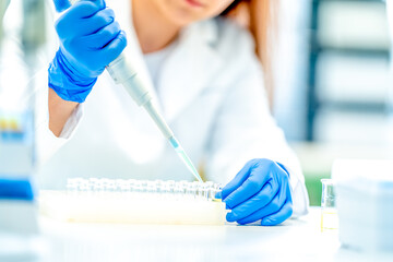 pipetting of chemical samples during research in a biochemical scientific laboratory