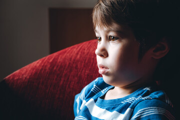 Tired eyes of 6 year boy looking at screen close-up. Child is watching TV, cartoons or video too...