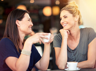 Conversation, cafe and female friends drinking coffee together while talking and bonding for gossip. Happy, smile and women speaking, laughing and enjoying a warm beverage at a restaurant in the city