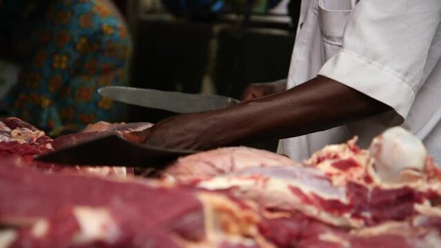 Butcher slicing fresh meat in a Lagos market. Nigeria