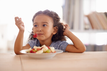 Eating child, breakfast and fruit salad at home with happiness and wellness meal with a smile. House, nutrition and young girl with healthy food and fruits of a hungry kid in the morning at a table