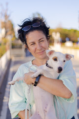 Woman walking with a white dog outside on a summer day