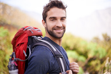 Hiking, smile and portrait of man on mountain for fitness, adventure and travel journey. Backpacking, summer and workout with male hiker trekking in nature path for training, freedom and explore © M Moller/peopleimages.com