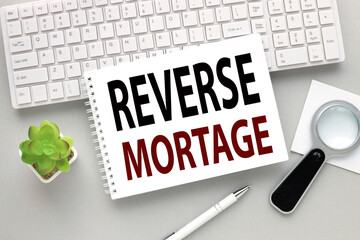 open notepad with Reverse mortgage text on white keyboard