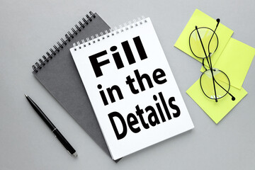 open notepad with text FILL IN THE DETAILS. on a gray background. two notebooks