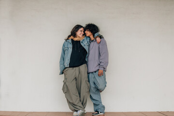happy teen couple hugging on wall