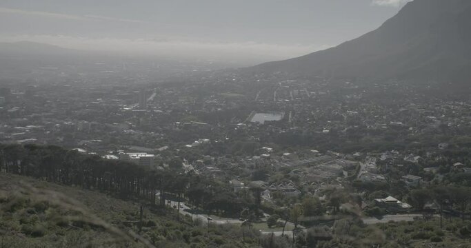 Panning shot filmed from the Lion's in Cape Town South Africa with the city down the valley on a cloudy day LOG