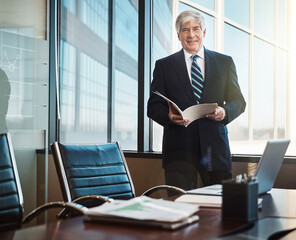 I proofread every piece of paperwork. Cropped portrait of a mature businessman reading paperwork in his office.