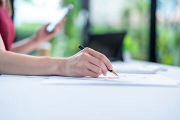 businesswoman hand writing on paper in office