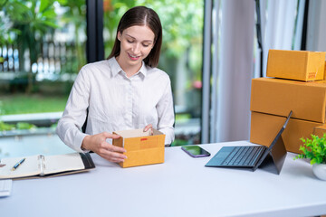 Startup, delivery and shipping in boxes for online shopping business. Businesswoman packing products from online business in a box to ship to clients and buyers.business woman working in the office