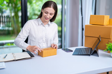 Startup, delivery and shipping in boxes for online shopping business. Businesswoman packing products from online business in a box to ship to clients and buyers.business woman working in the office