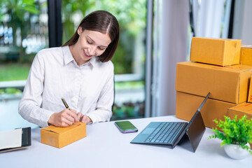 Startup, delivery and shipping in boxes for online shopping business. Businesswoman packing products from online business in a box to ship to clients and buyers.business woman working in the office