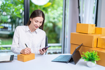 Startup, delivery and shipping in boxes for online shopping business. Businesswoman packing products from online business in a box to ship to clients and buyers.business woman working in the office