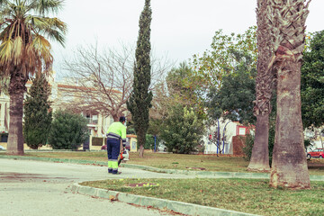 a girl in uniform cleans the streets with street cleaning equipment, a worker cleans the streets