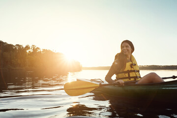 When life gets complicated, go kayaking. a beautiful young woman kayaking on a lake outdoors. - obrazy, fototapety, plakaty