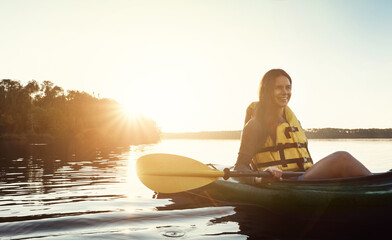 Im glad I got to go kayaking. a beautiful young woman kayaking on a lake outdoors.