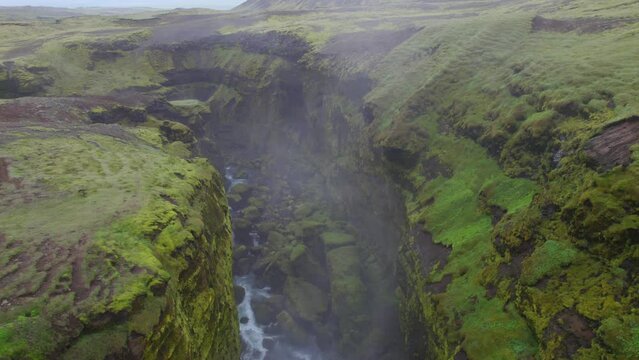 Aerial over the rugged terrain near the famous natural landmark and tourist attraction of Skogafoss falls and Fimmvorduhals trail in Iceland. Drone pan left to right shot
