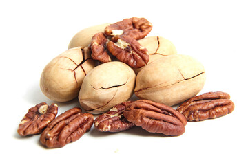 Pecan nuts in shell and peeled pecan kernels isolated on a white. Whole and halves of pecan nuts