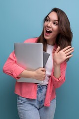 positive successful freelance brunette young woman in shirt and jeans with laptop