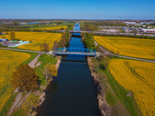 bridge crossing canal in rape fields