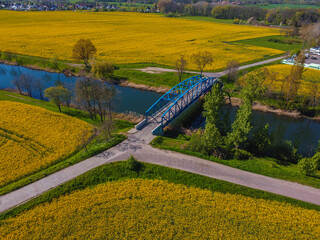 bridge crossing canal in rape fields